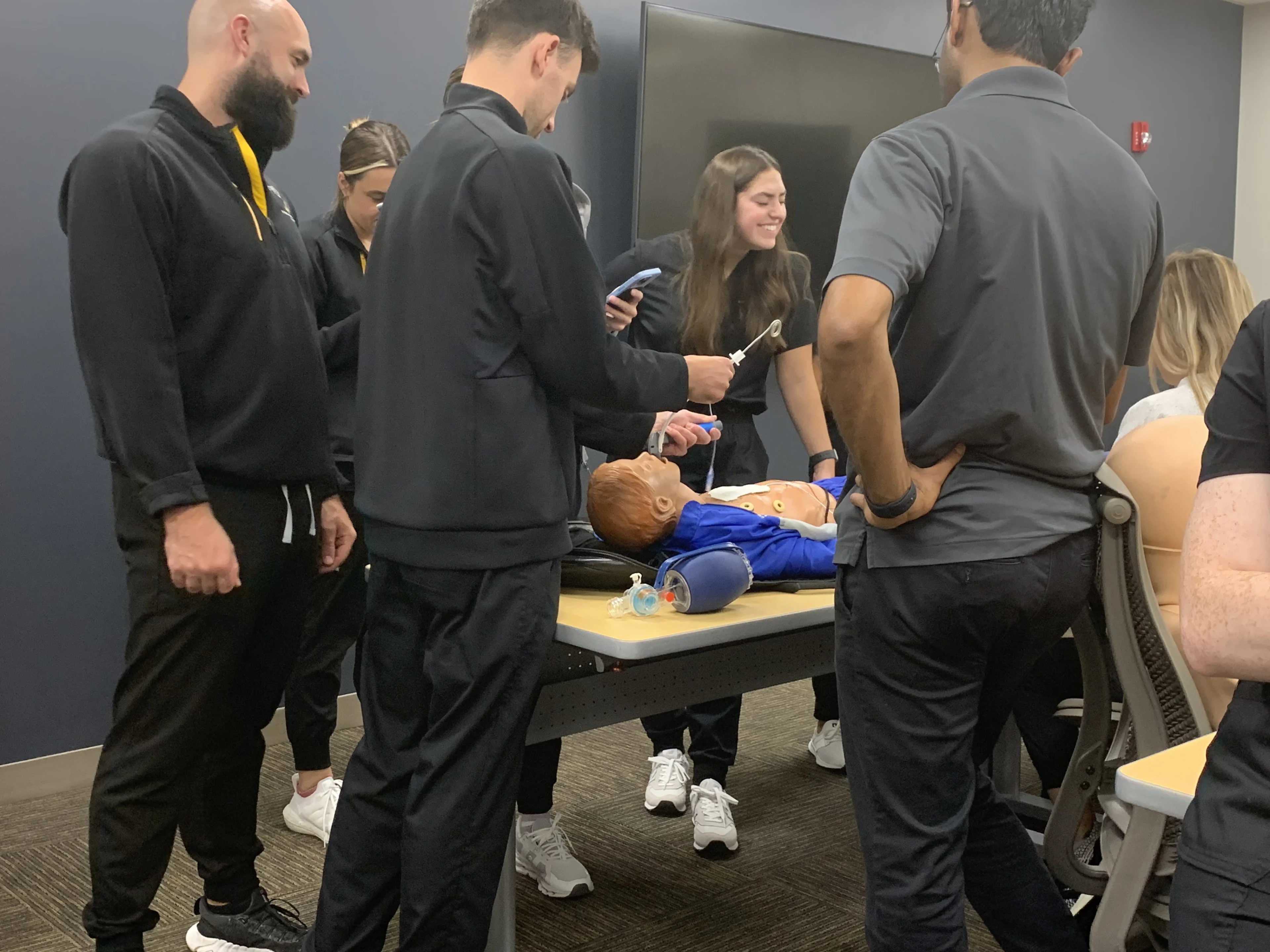 Group practicing CPR on mannequin